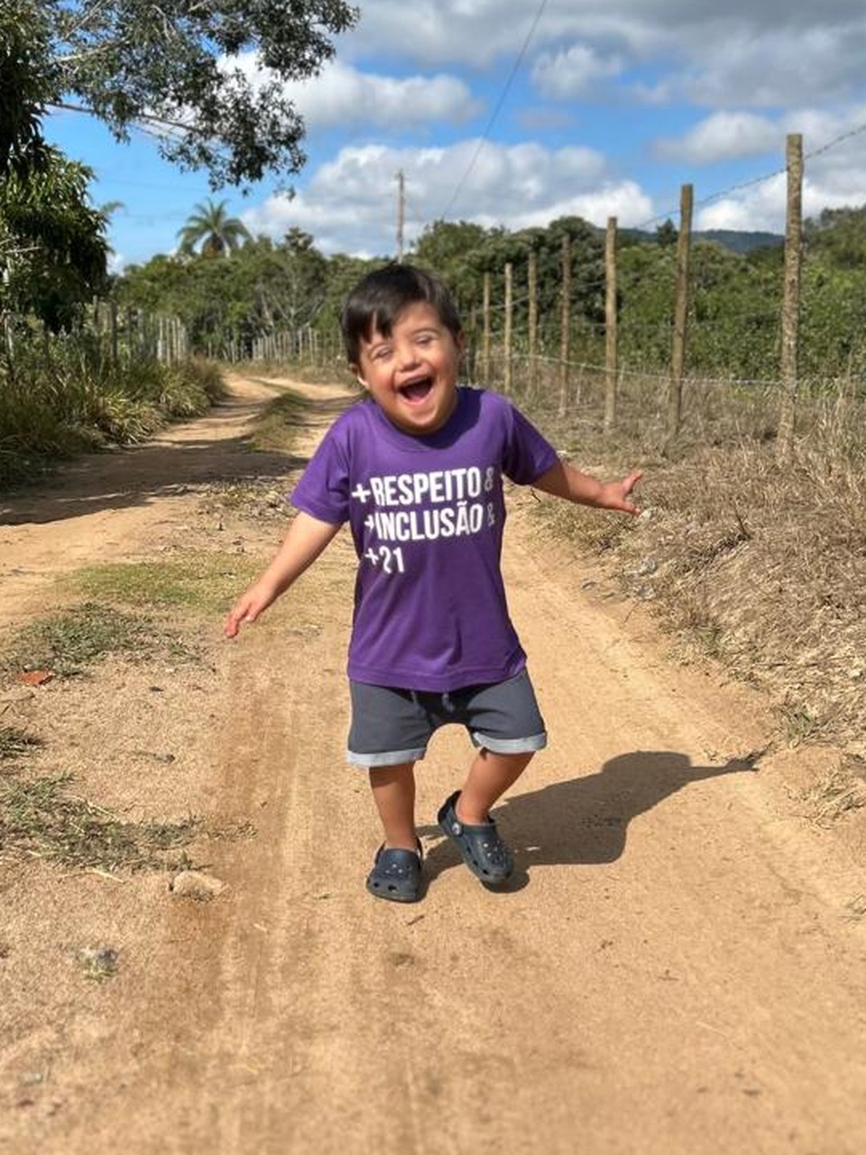 O Nauê hoje, correndo e sorrindo numa estrada de terra, de camiseta roxa escrita “respeito, inclusão”
