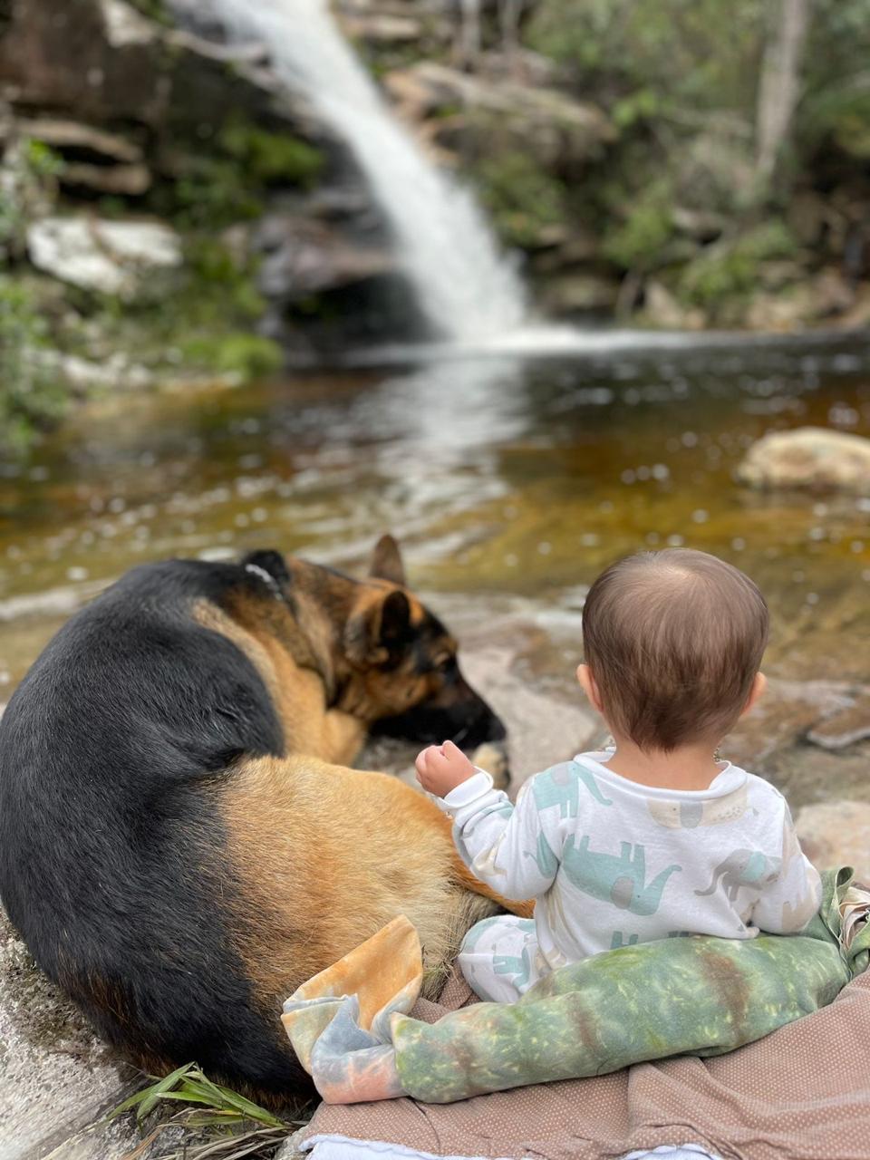O Nauê na natureza, diante de uma cachoeira
